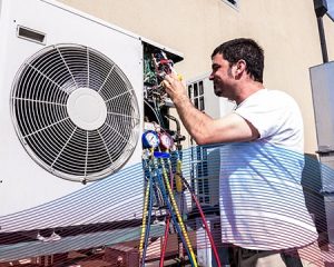 Technician in White Performing A/C Maintenance