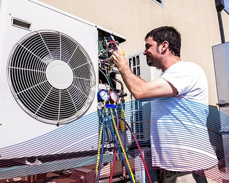 Technician in White Performing A/C Maintenance